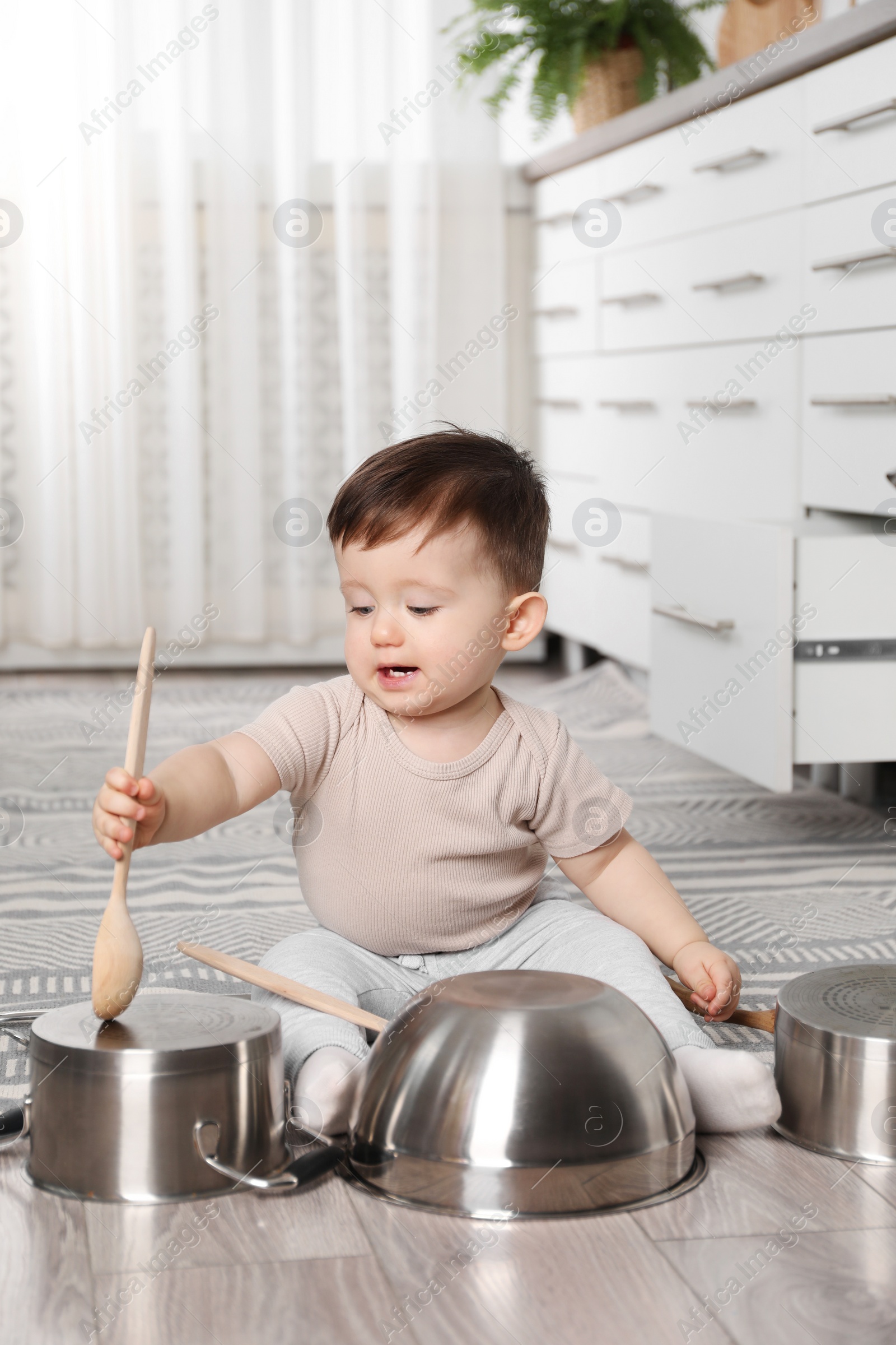 Photo of Cute little boy with cookware at home