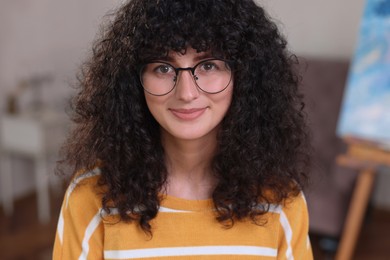 Portrait of happy young woman in stylish glasses indoors