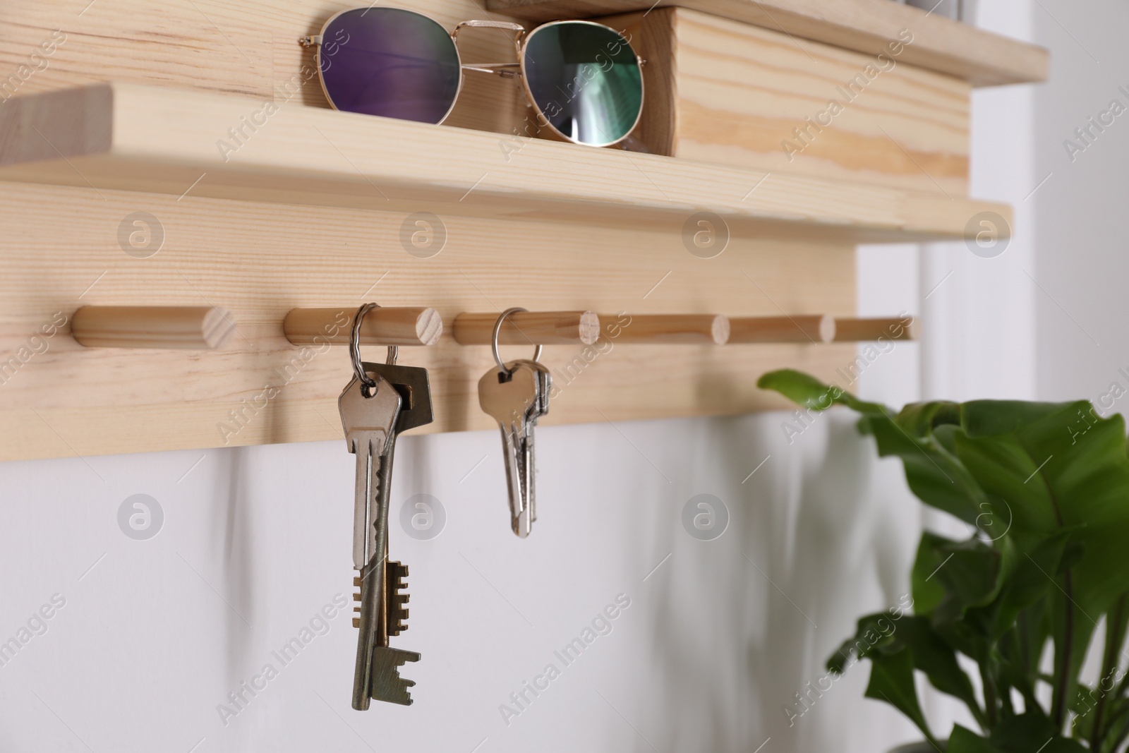 Photo of Wooden hanger for keys on white wall, closeup