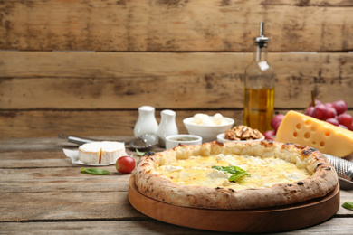 Delicious cheese pizza on wooden table. Space for text