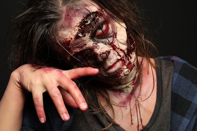 Photo of Scary zombie on dark background, closeup. Halloween monster