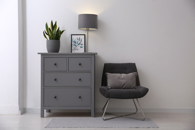 Grey chest of drawers in stylish room interior