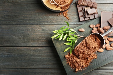 Photo of Flat lay composition with cocoa powder, beans and chocolate on wooden table