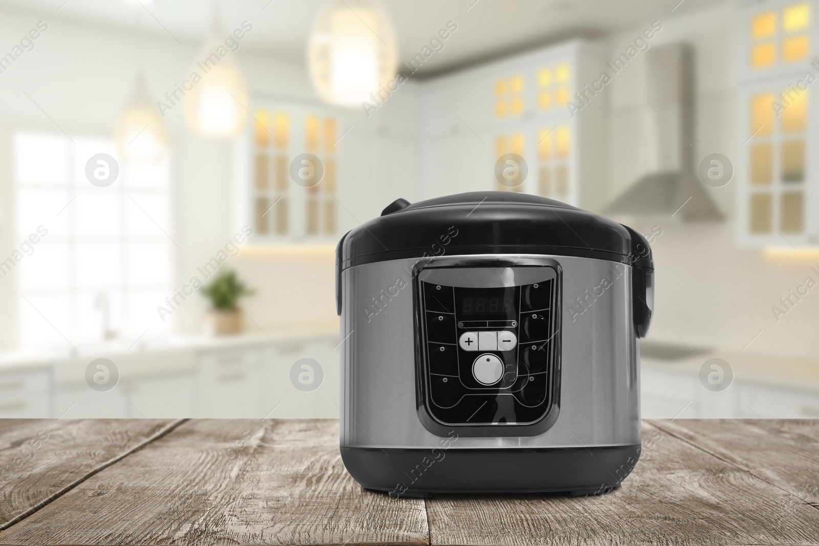 Image of Modern electric multi cooker on wooden table in kitchen. Space for design