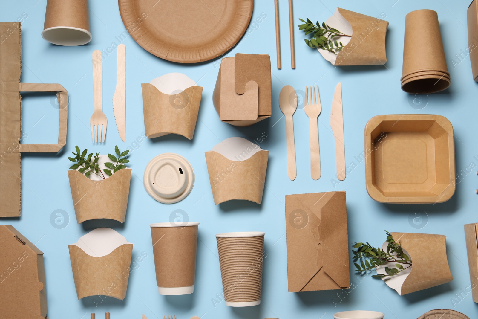 Photo of Flat lay composition with eco friendly food packagings and twigs on light blue background