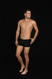 Photo of Handsome man in underwear on black background