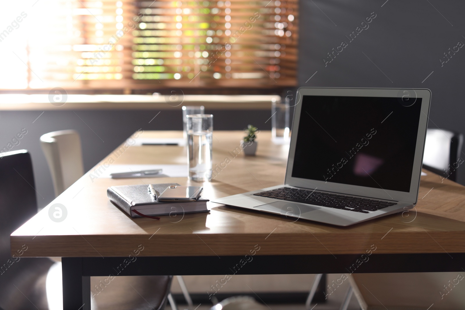 Photo of Laptop on wooden table in modern office