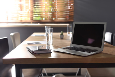 Laptop on wooden table in modern office