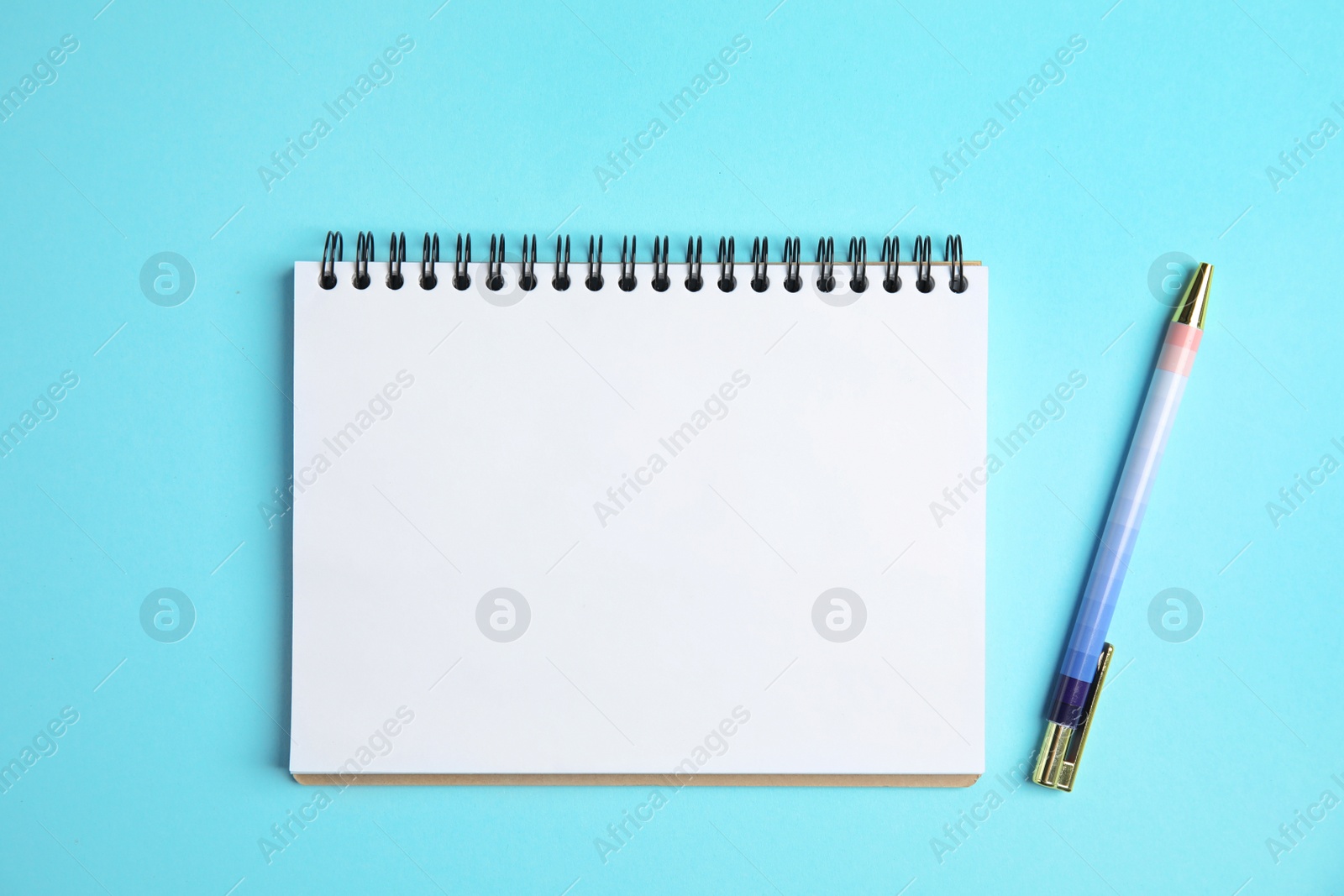 Photo of Empty notebook and pen on color background, top view