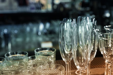 Different empty clean glasses on counter in bar, closeup