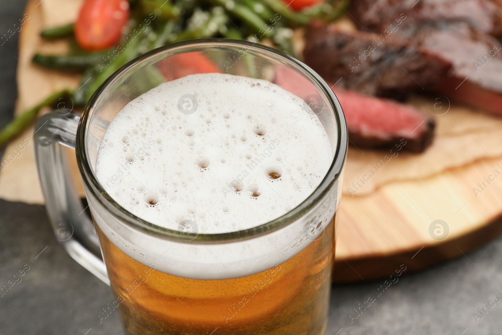 Photo of Glass mug with tasty beer on table, closeup