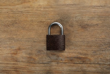 Photo of Modern padlock on wooden table, top view