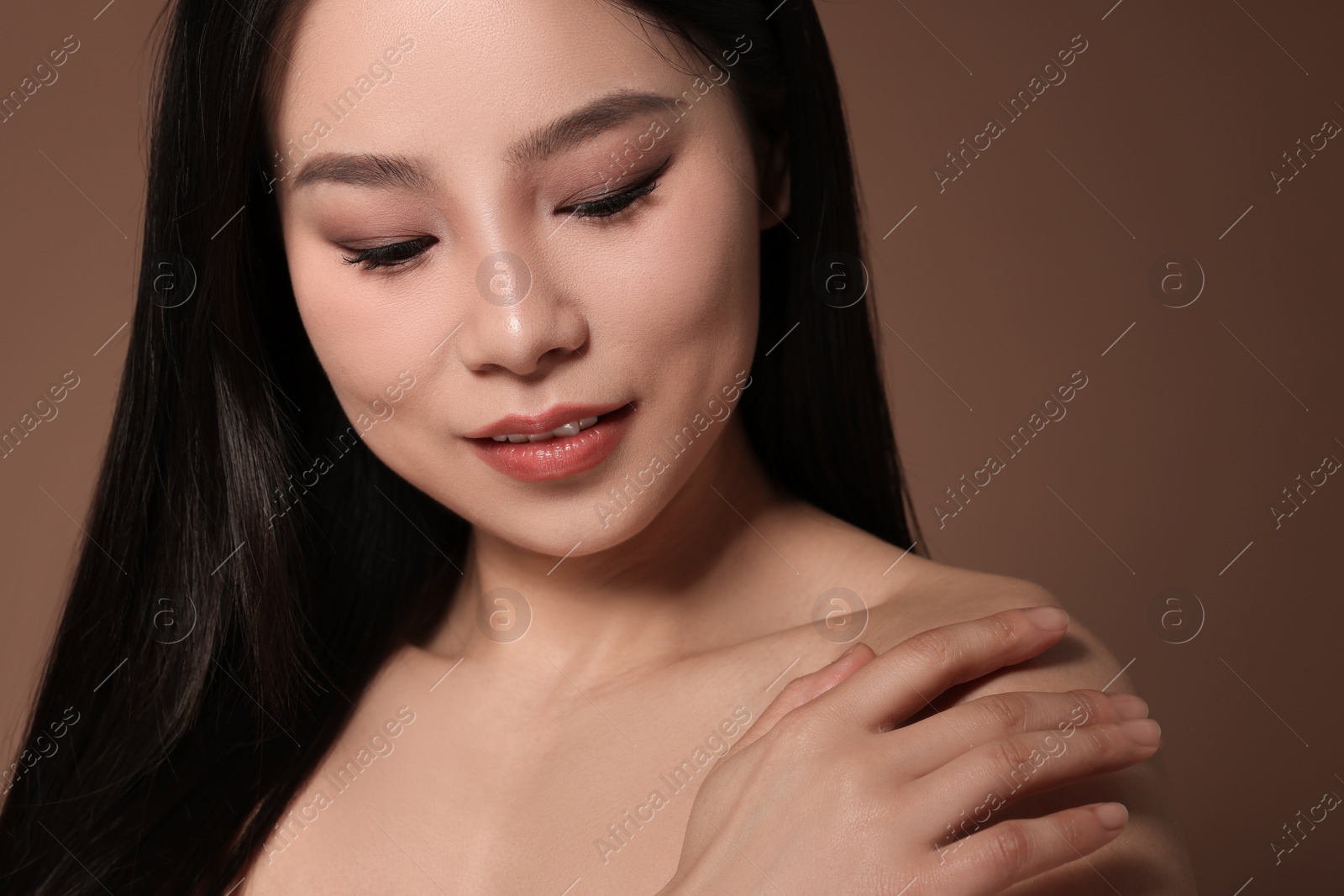 Photo of Portrait of beautiful woman on brown background, closeup