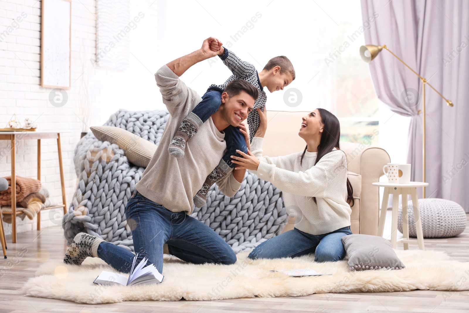 Photo of Happy family with little son having fun at home. Winter vacation