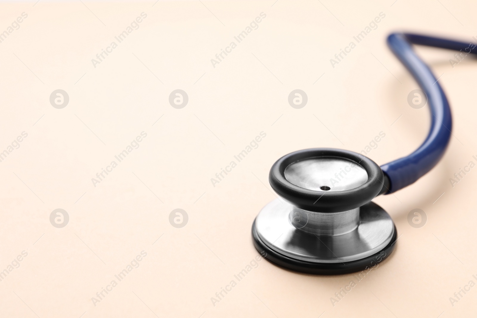 Photo of Stethoscope on beige background, closeup. Space for text