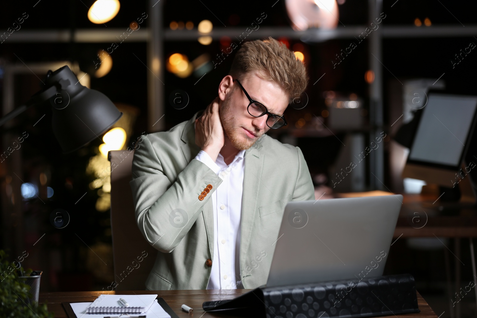 Photo of Young man working in office at night