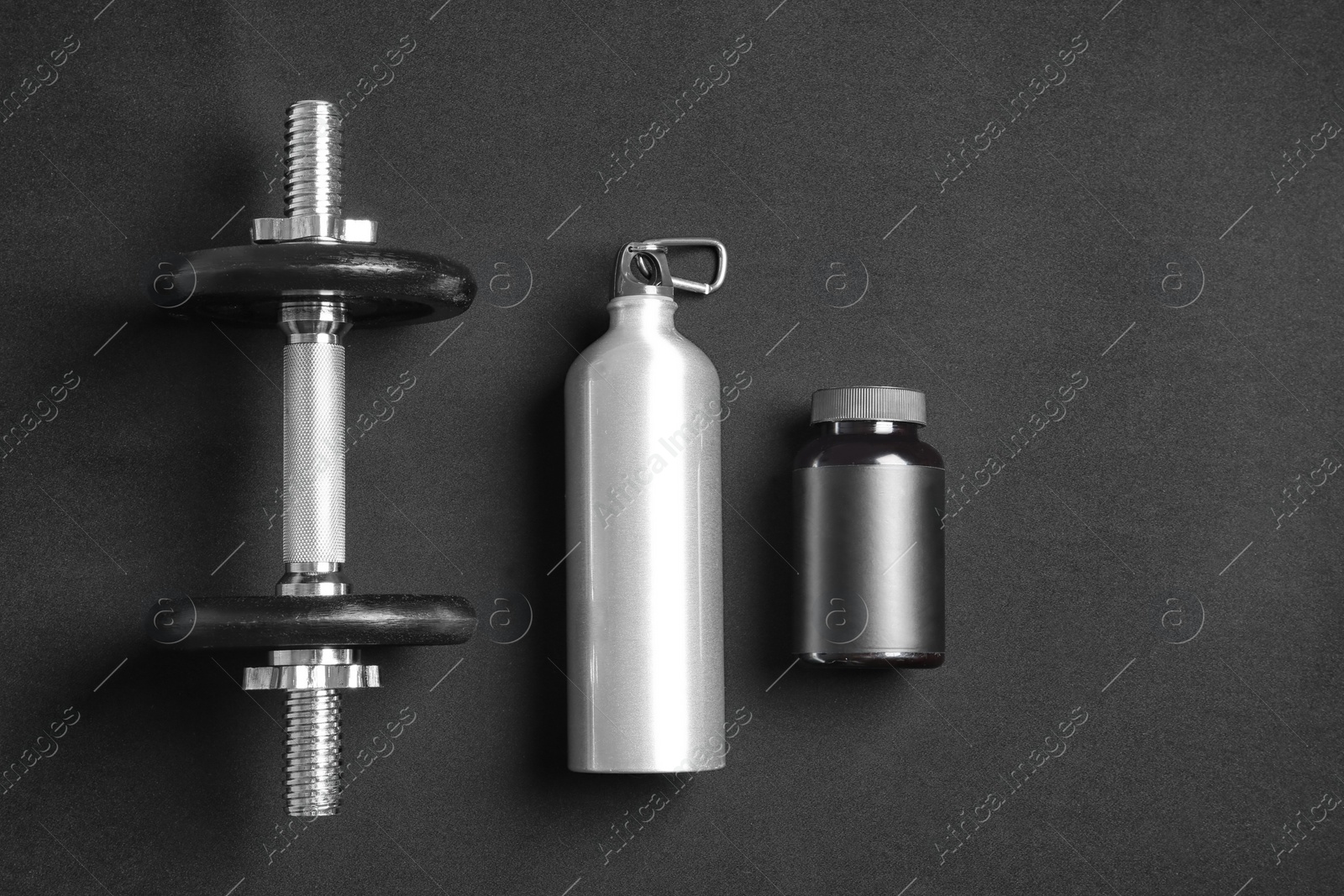 Photo of Flat lay composition with dumbbell on dark background