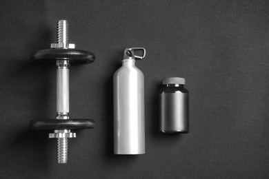 Photo of Flat lay composition with dumbbell on dark background