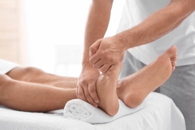 Photo of Young woman receiving massage in salon, closeup