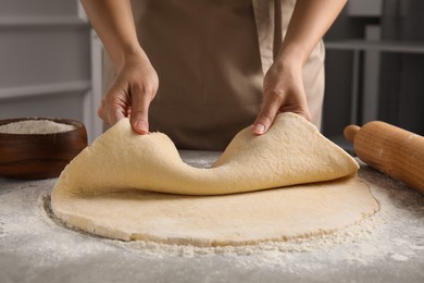 Woman with fresh dough at table, closeup