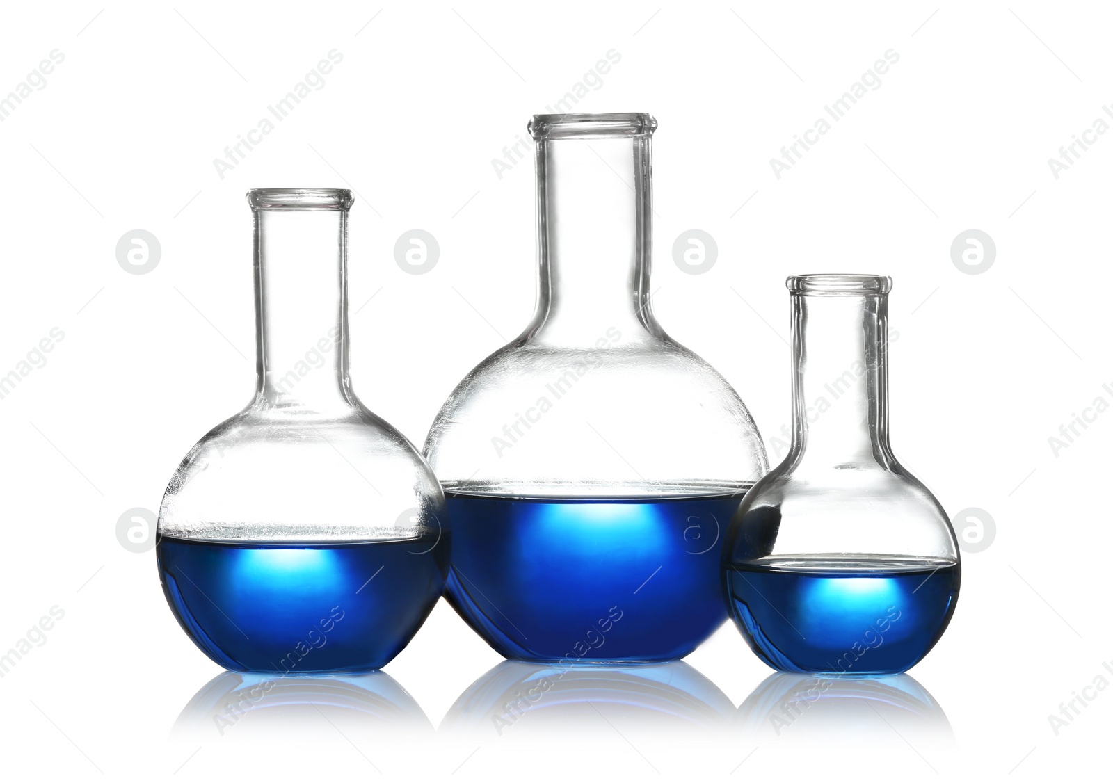 Photo of Florence flasks with liquid samples on white background. Chemistry glassware