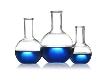 Photo of Florence flasks with liquid samples on white background. Chemistry glassware