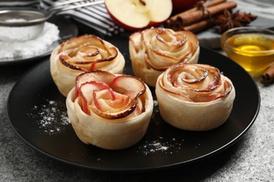 Photo of Freshly baked apple roses on grey table. Beautiful dessert