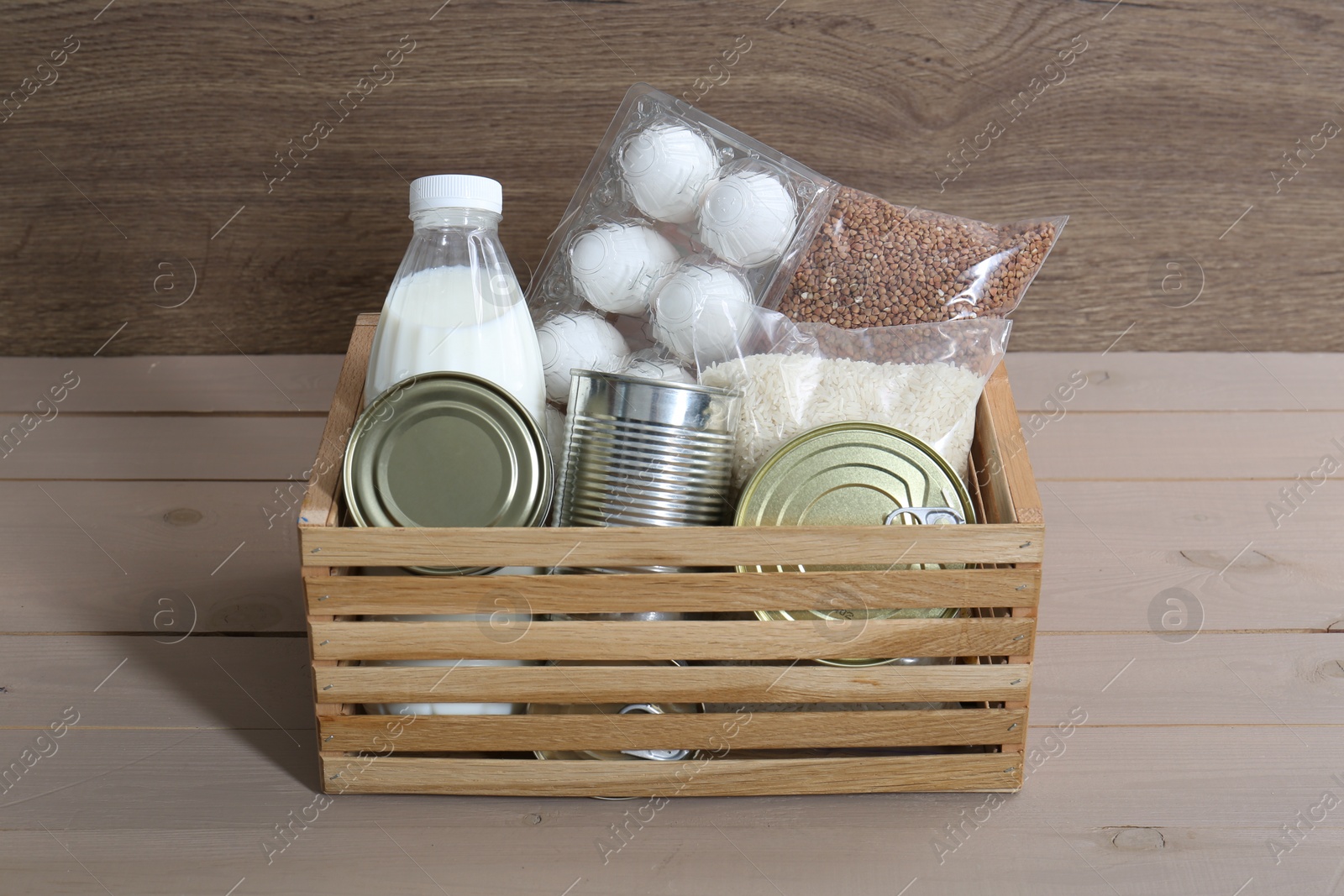 Photo of Donation box with food products on wooden table