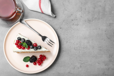 Tasty cake with berries on grey table, flat lay. Space for text