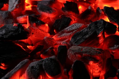 Photo of Pieces of hot smoldering coal as background, closeup