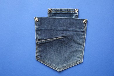 Photo of Stylish jeans pockets on blue background, top view