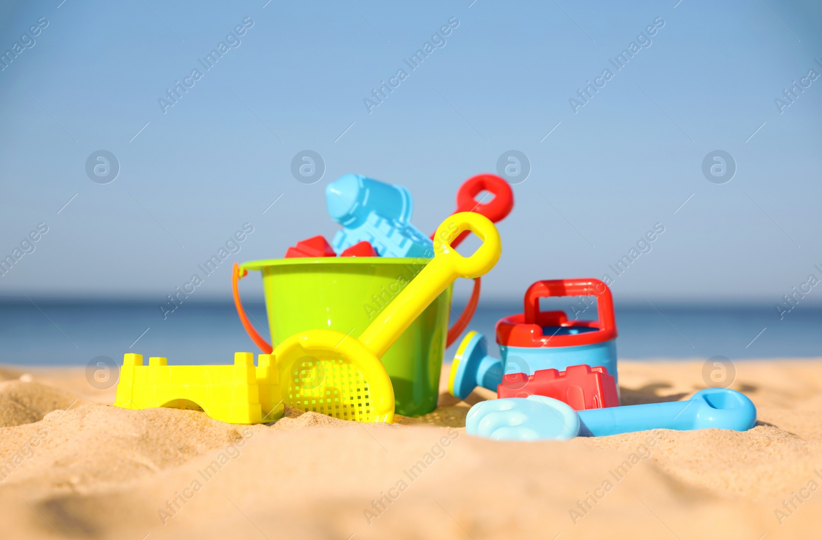 Photo of Different child plastic toys on sandy beach