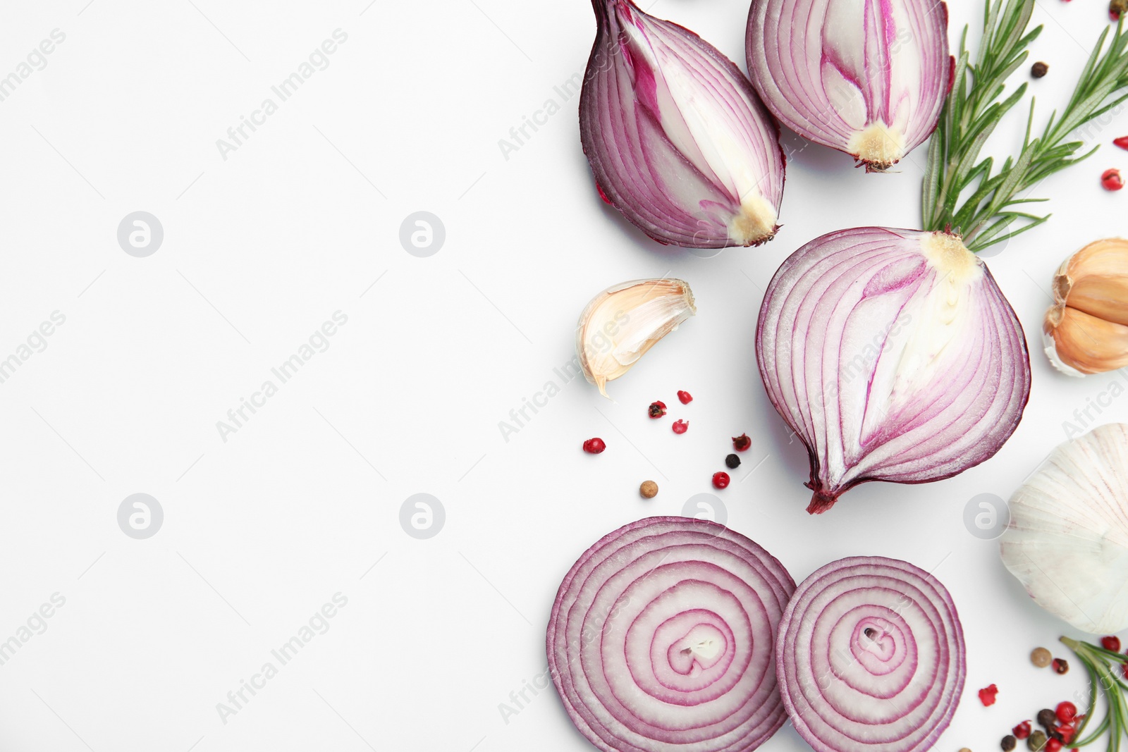 Photo of Fresh red onions, garlic, rosemary and spices on white background, flat lay. Space for text