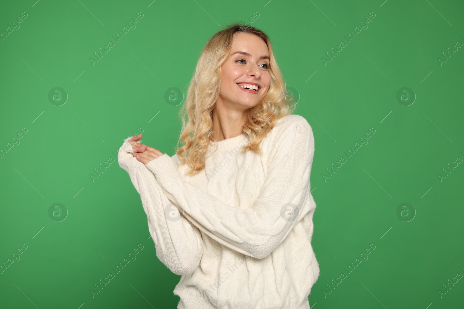 Photo of Happy woman in stylish warm sweater on green background