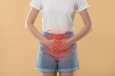 Image of Woman suffering from cystitis symptoms on beige background, closeup