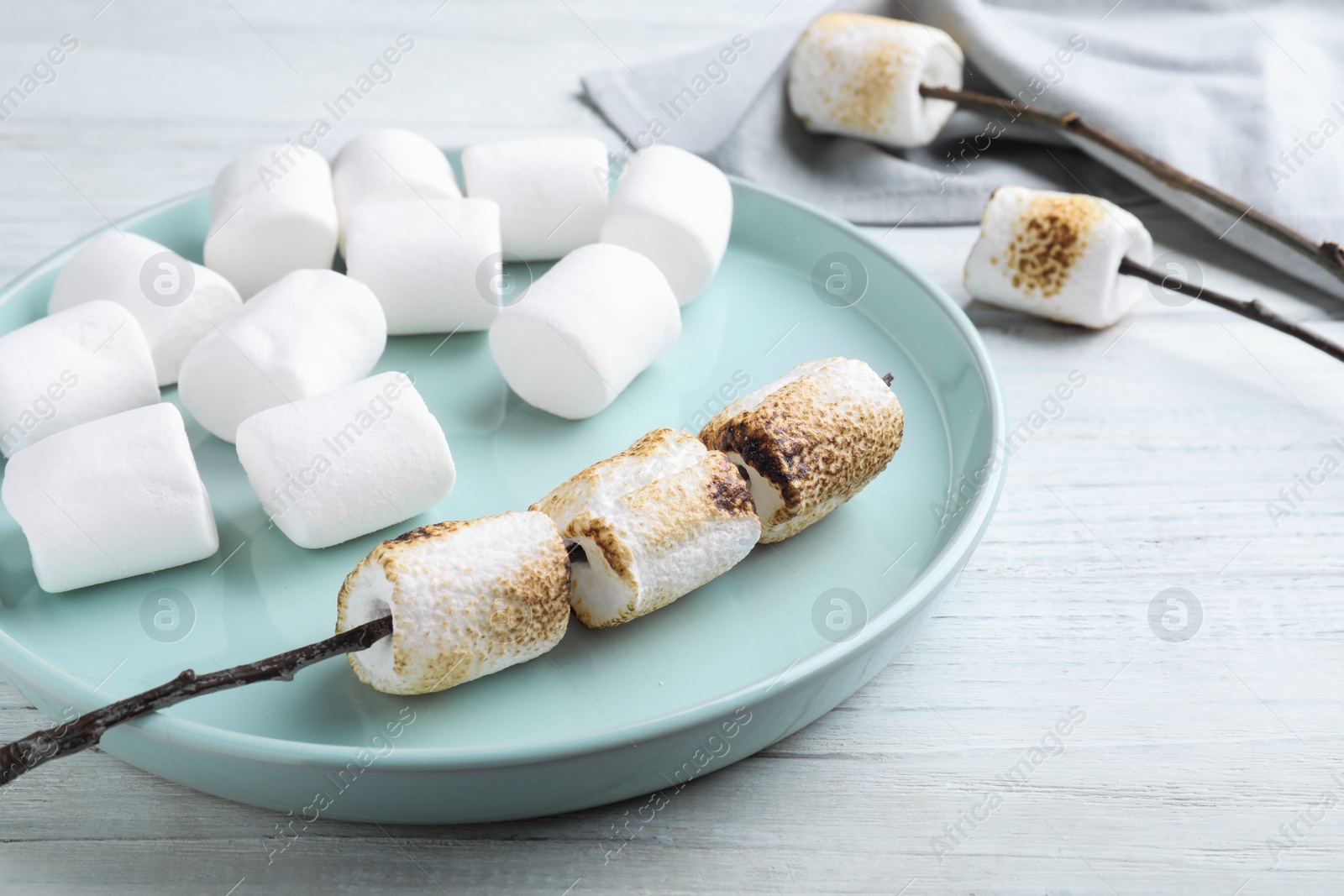 Photo of Fresh and roasted marshmallows on white wooden table