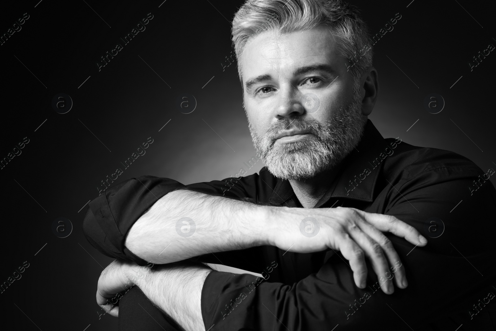 Photo of Portrait of handsome man on dark background. Black and white effect