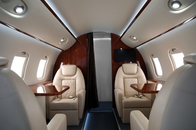 Image of Airplane cabin with comfortable seats and tables