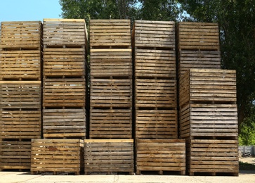 Pile of empty wooden crates outdoors on sunny day