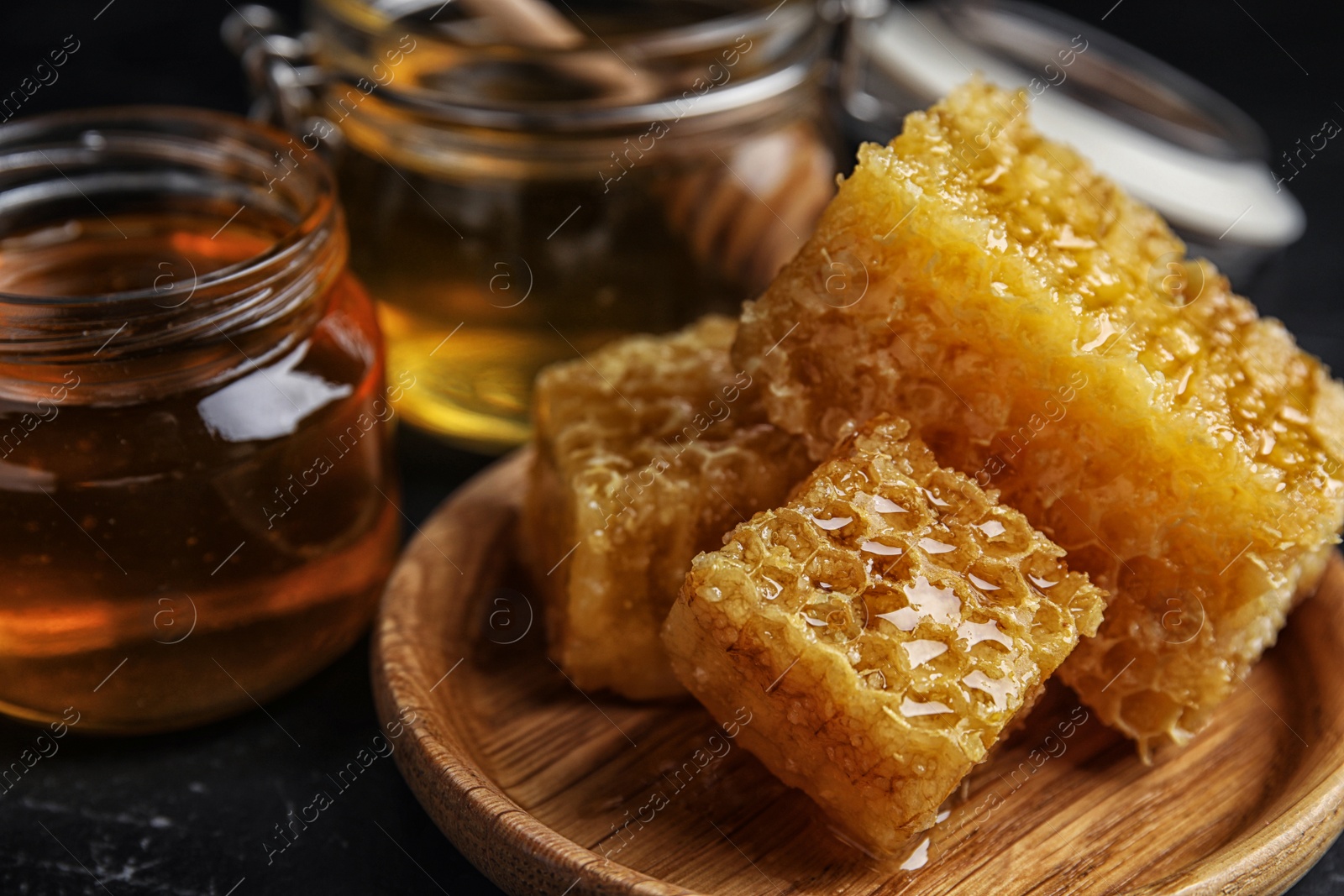 Photo of Composition with fresh honey on black table, closeup