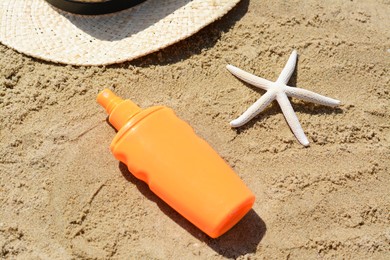 Photo of Blank bottle of sunscreen and starfish on sand at beach