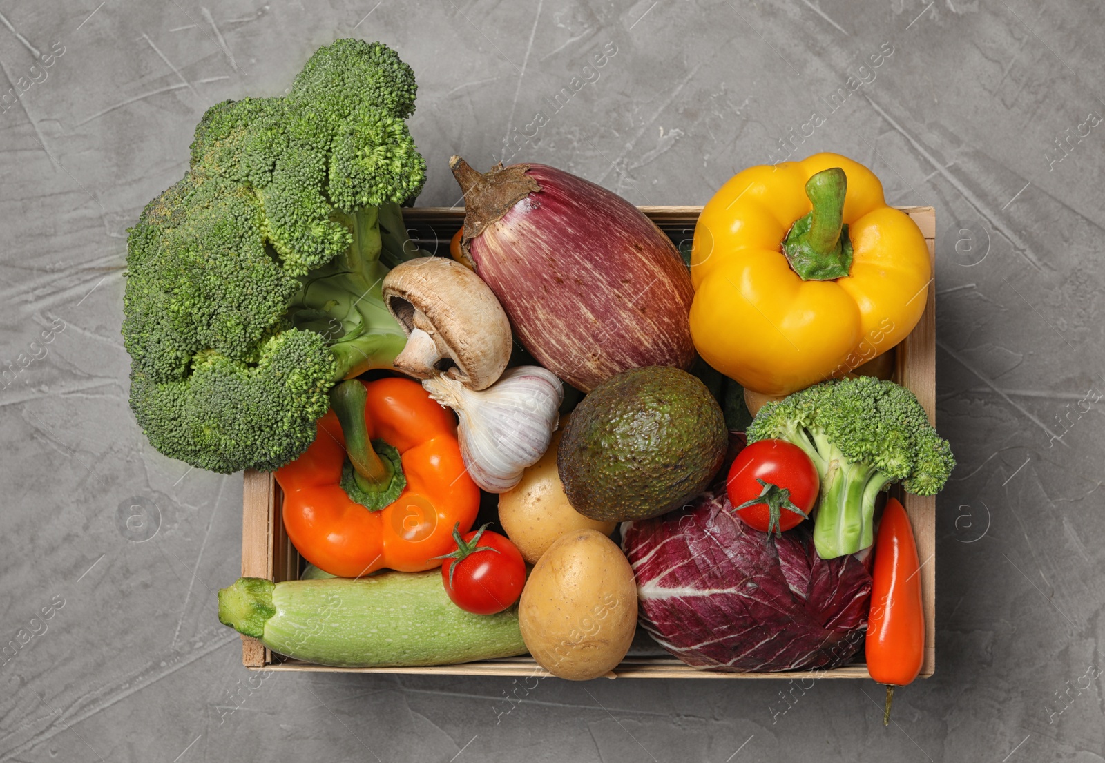 Photo of Crate with different fresh vegetables on grey background, top view