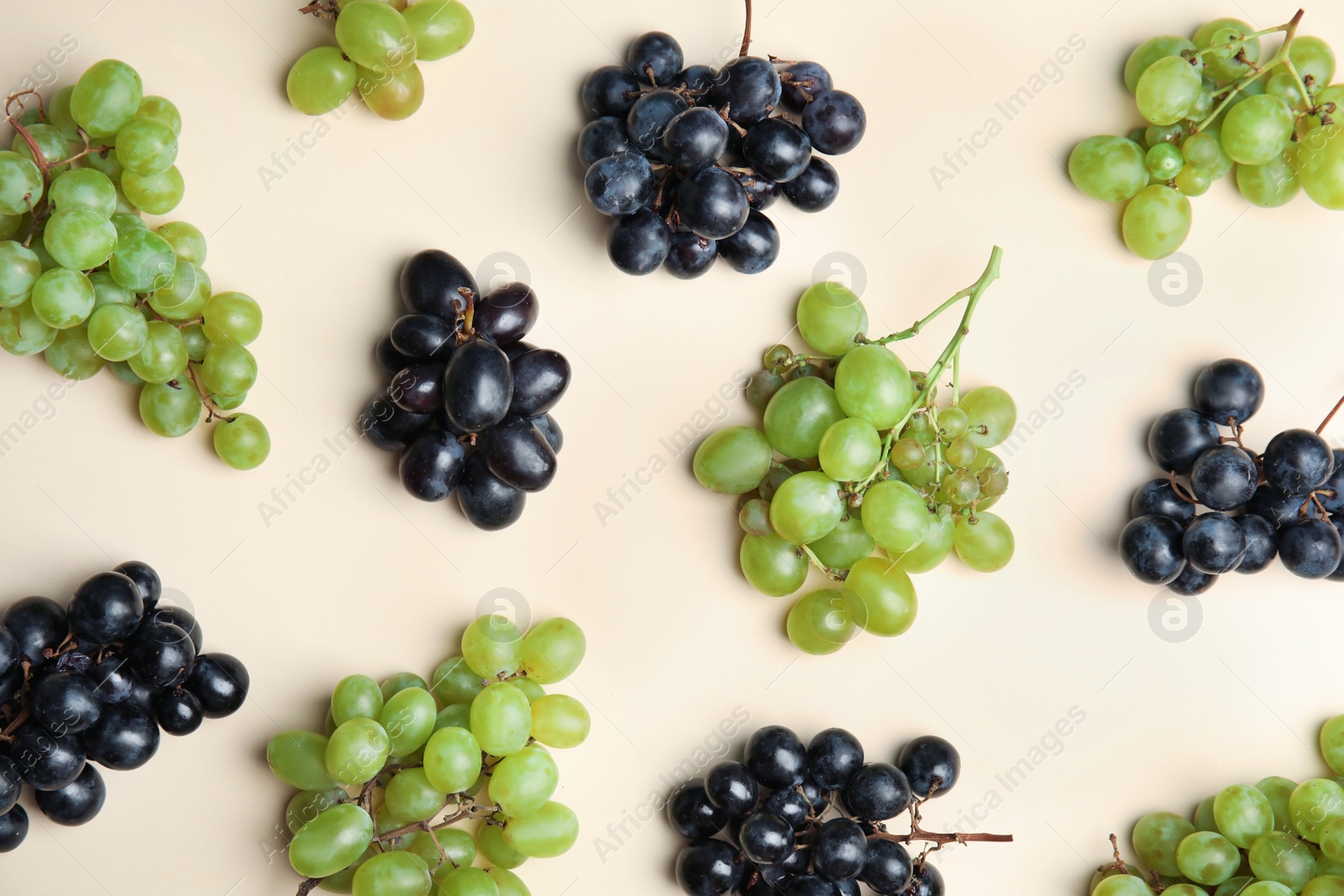 Photo of Different fresh ripe juicy grapes on color background, top view