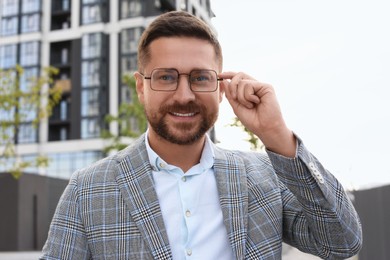 Photo of Portrait of handsome bearded man in glasses outdoors