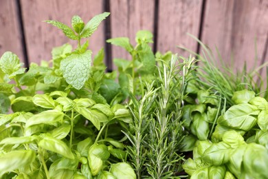Photo of Different aromatic herbs on wooden background, closeup