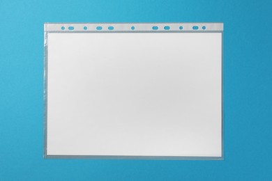 Photo of Punched pocket with paper sheet on light blue background, top view
