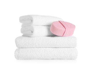 Photo of Stack of clean soft towels and sponge on white background