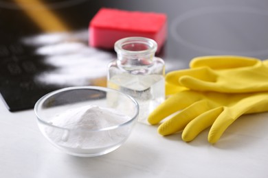 Baking soda, vinegar and gloves on white table. Eco friendly detergent