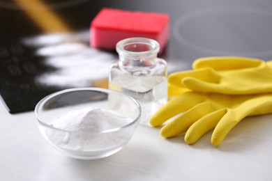 Photo of Baking soda, vinegar and gloves on white table. Eco friendly detergent