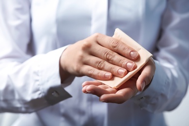 Photo of Woman cleaning hands with paper napkin, closeup